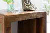 A close-up of a wooden side table with a decorative Buddha statue and a glass vase with a plant on top. Podgląd zdjęcia produktu
