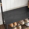 A close-up view of a black wooden shelf on a coat rack, with shoes on the shelf below. Produktbild-Vorschau