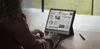 A person is using a BOOX Note Air5 C e-reader/tablet in a modern office setting. Produktbild-Vorschau