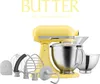 A yellow KitchenAid stand mixer with various attachments and bowls. Produktbild-Vorschau
