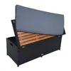 A black rattan storage bench with the lid open, revealing a wooden interior and a gray cushion on top. Produktbild-Vorschau