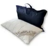 A white pillow with a quilted pattern and a label is placed in front of a black zippered bag. Produktbild-Vorschau
