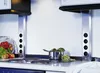 A kitchen counter with a stovetop, a pot of vegetables, and a fruit basket. Produktbild-Vorschau