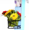 A close-up view of a miniature house accessory, featuring a small basket filled with colorful artificial flowers. Anteprima dell’immagine prodotto