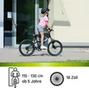 A young girl is riding a bicycle outdoors, next to a building. Produktbild-Vorschau
