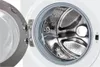 Close-up view of the inside of a washing machine drum with the door open. Voir les images du produit