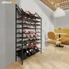 A wine rack filled with bottles in a modern interior setting with a table and chairs. Náhľad obrázku produktu