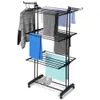 A black metal drying rack with wheels, loaded with various folded clothes and towels. Produktbild-Vorschau