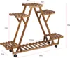 A wooden plant stand with multiple tiers and wheels, shown with dimensions indicated by red lines and text. Produktbild-Vorschau