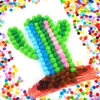 A craft project featuring a cactus made of colorful pom-poms on a white background, surrounded by scattered pom-poms. Produktbild-Vorschau