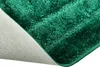 A close-up view of the corner of a green bath mat, showing the textured pile and the non-slip backing. Náhled obrázku produktu