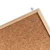 A close-up view of a cork bulletin board with a wooden frame and metal hanging hooks. Náhľad obrázku produktu