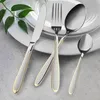 A set of cutlery on white plates with green leaves. Produktbild-Vorschau