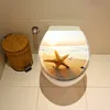 A toilet seat with a beach scene and starfish design, next to a woven trash can. Náhled obrázku produktu