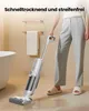A person is using a wet dry vacuum cleaner on a wet floor in a bathroom. Produktbild-Vorschau