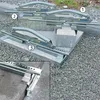 Three concrete block lifters are shown in use on a gravel and concrete block surface. Podgląd zdjęcia produktu