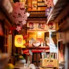 A miniature diorama of a Japanese alleyway with a ramen shop and cherry blossoms. Voir les images du produit