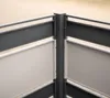 A close-up view of a corner of a modern outdoor trash bin enclosure, showing the dark gray metal frame and beige panels. Náhled obrázku produktu