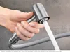 A hand holding a kitchen faucet spray head with water running out. Produktbild-Vorschau