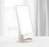 A makeup mirror with LED lights is placed on a white surface in front of a blurred background of white curtains. Produktbild-Vorschau