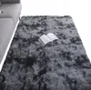 A dark gray shaggy rug is shown in a room, with a portion of a gray sofa visible on the left. An open book lies on the rug. Podgląd zdjęcia produktu
