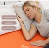 A woman sleeping on a bed with a pillow, with text overlays highlighting product features. Produktbild-Vorschau