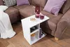 Weißer Beistelltisch 50x50x30cm Holz mit offenen Fächern, frontal zwischen braunem Sofa mit Dekokissen positioniert. Productafbeelding-voorbeeld