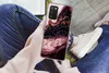 A person is holding a smartphone with a marble-patterned case while sitting down. Produktbild-Vorschau