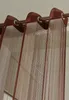 Close-up of brown string curtains hanging from a metal rod. Produktbild-Vorschau