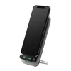 A black smartphone is placed on a gray wireless charging stand. Produktbild-Vorschau