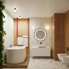A modern, luxurious bathroom with a freestanding bathtub, a wall-mounted vanity with a sink and round mirror, and a bidet and toilet. Produktbild-Vorschau