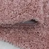 A close-up view of a pink shaggy rug, showing its texture and the underside where it is folded. Anteprima dell’immagine prodotto