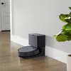 A robot vacuum cleaner docked at its charging station next to a wall. Voir les images du produit