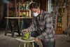 A man is sanding a stool in a workshop. Podgląd zdjęcia produktu