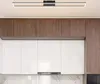 A modern kitchen interior with white cabinets, wood-paneled upper cabinets, and a sleek black rectangular LED ceiling light. Voir les images du produit