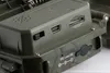 A close-up view of the ports and battery compartment of a camouflage-patterned electronic device. Produktbild-Vorschau