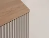 A close-up view of the top corner of a cabinet with a wooden top and a fluted front. Náhľad obrázku produktu