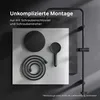 A flat lay of a black shower system including a rain shower head, hand shower, and hose, arranged on a light gray surface with a dark gray textured background element. Produktbild-Vorschau