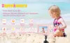A child is sitting on a beach next to a pink digital camera on a tripod. Produktbild-Vorschau
