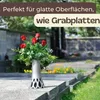 A vase with red roses placed on a grave in a cemetery. Produktbild-Vorschau