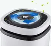Close-up of the top of a white and black air purifier with blue arrows indicating 360-degree airflow and green leaves floating around. Voir les images du produit
