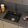 A modern kitchen sink with a black faucet and a dark countertop. Podgląd zdjęcia produktu
