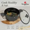 A pot of vegetables cooking in water, with its glass lid placed next to it. The pot is on a wooden cutting board. Produktbild-Vorschau