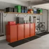 A garage or storage area with organized shelves and cabinets, featuring various storage bins, tools, and a bicycle. Voir les images du produit