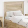 A close-up view of a bed with a headboard and bedding. Voir les images du produit