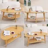 A collage of four images showing a wooden coffee table from different angles, styled with books, a vase with flowers, and fruit. Voir les images du produit
