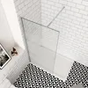 A modern bathroom with white subway tiles and a black and white geometric floor. Produktbild-Vorschau