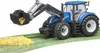 A toy tractor with a front loader is shown scooping up a pile of yellow kernels, likely representing corn. Anteprima dell’immagine prodotto