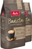 Two bags of Melitta Barista Caffè Crema coffee beans are shown, with one bag in the foreground and the other slightly behind it. A stylized illustration of a woman is on the front of the bag, and a cup of coffee with latte art is also depicted. Produktbild-Vorschau
