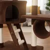 A close-up view of a brown cat tree with scratching posts and a tunnel. Náhľad obrázku produktu